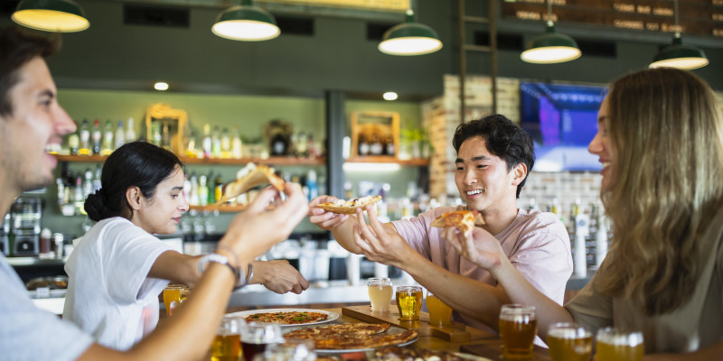 friends enjoying dining out with pizza