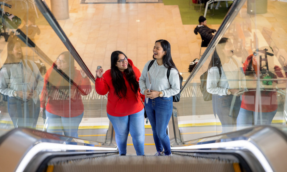 Students smiling on escalator